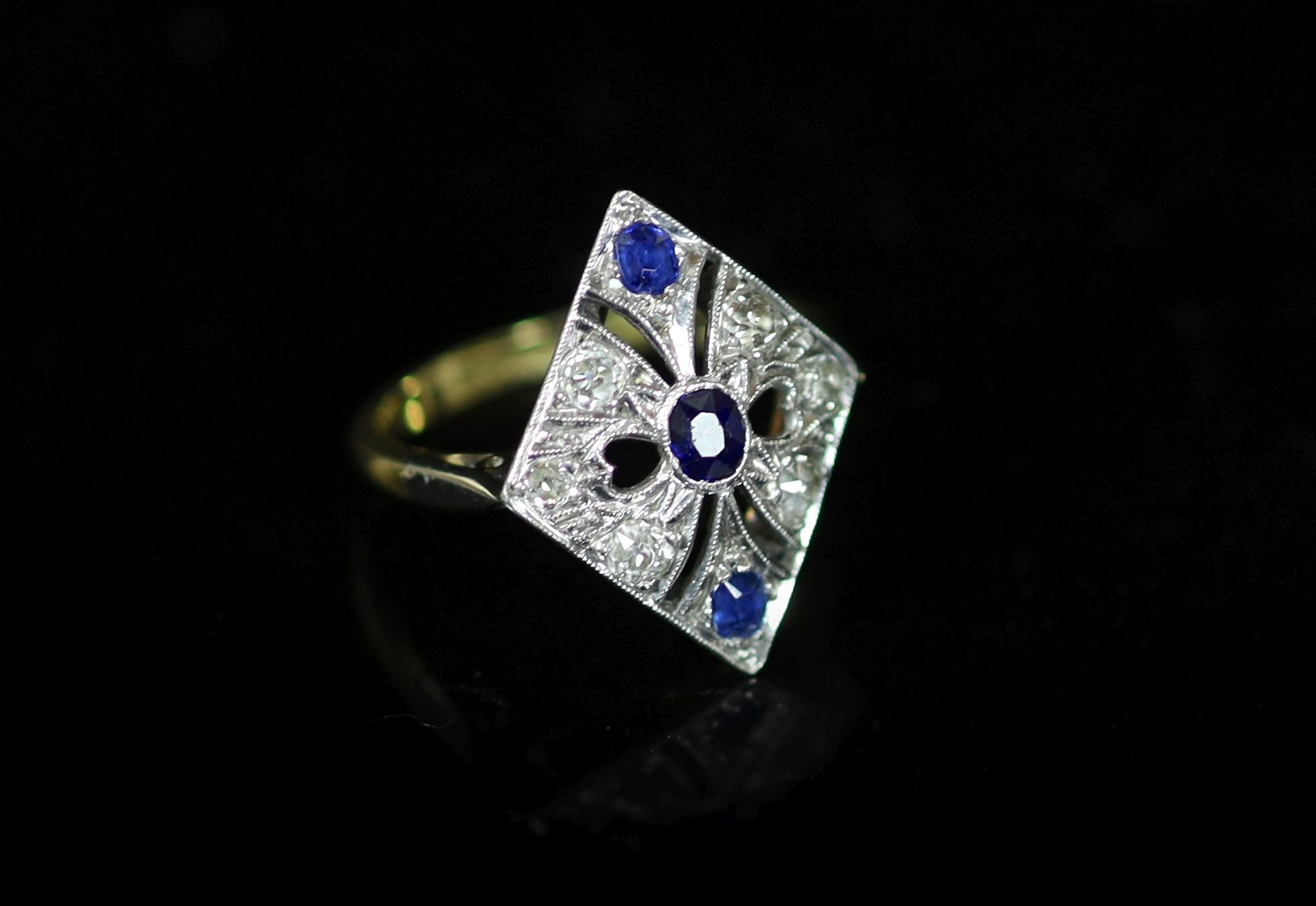 A 1920's/1930's 18ct gold and platinum, millegrain set sapphire and diamond pierced diamond shaped dress ring